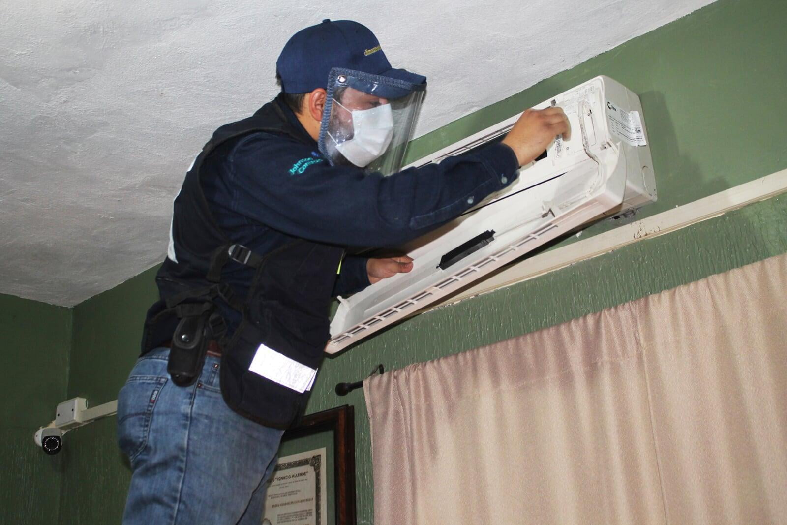 La persona está destapando el equipo de aire acondicionado